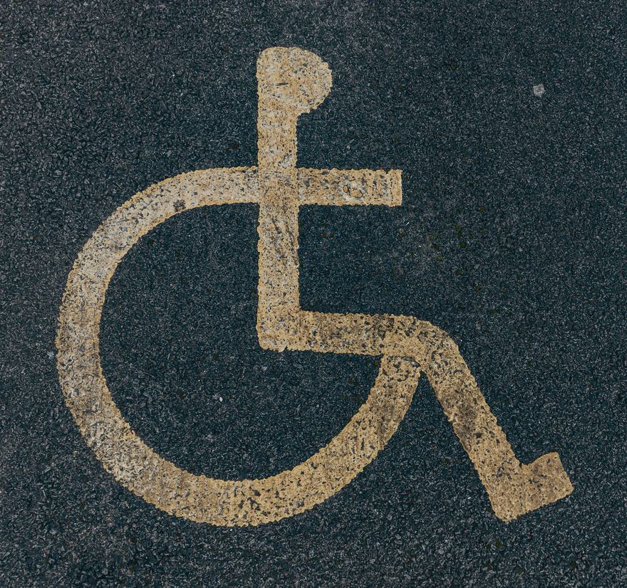 Rollstuhl-Symbol auf Asphalt markiert – Symbolbild für die Führerscheinausbildung mit Handicap bei der Fahrschule Clauser